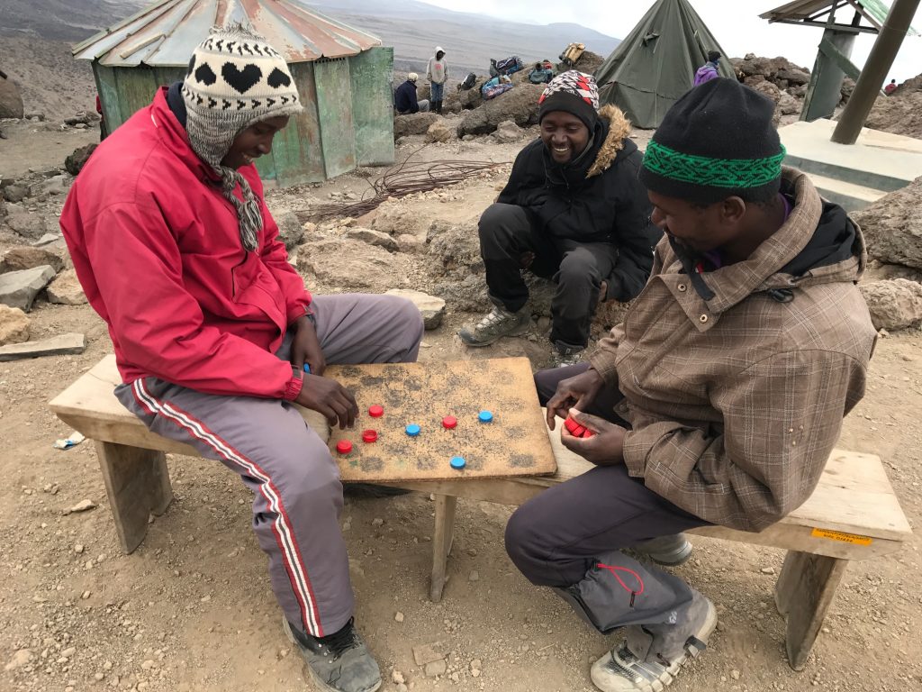 Porters playing "Draughts" in Barafu Camp, a Tanzanian form of checkers.